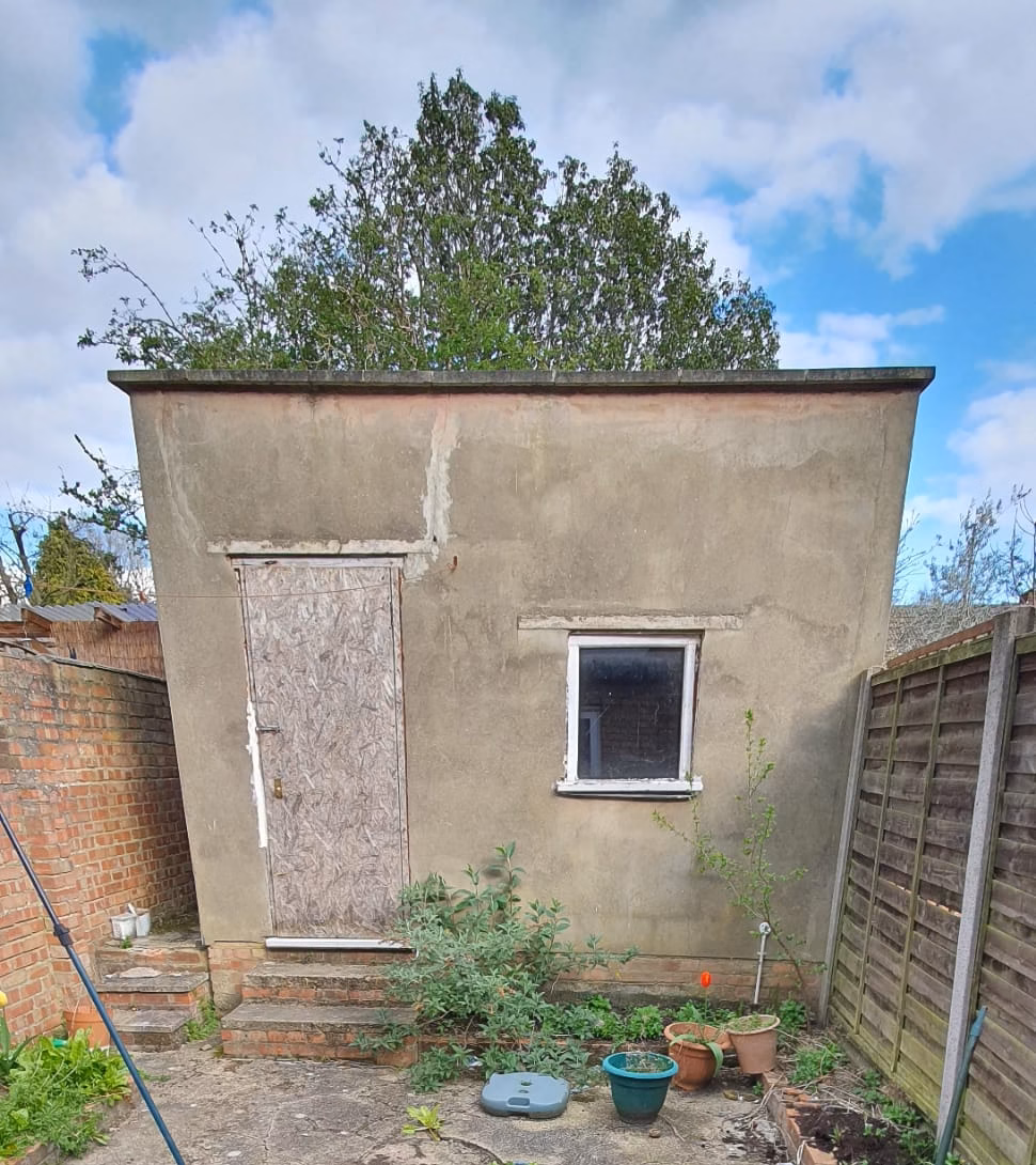 Rear yard before conversion — overgrown garden