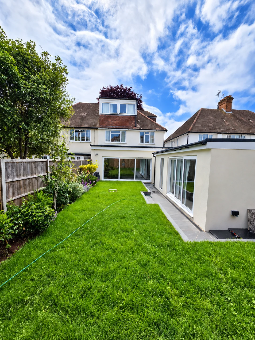 Completed glazed rear extension and new garage beside a landscaped garden in Finchley, NW7 2LJ